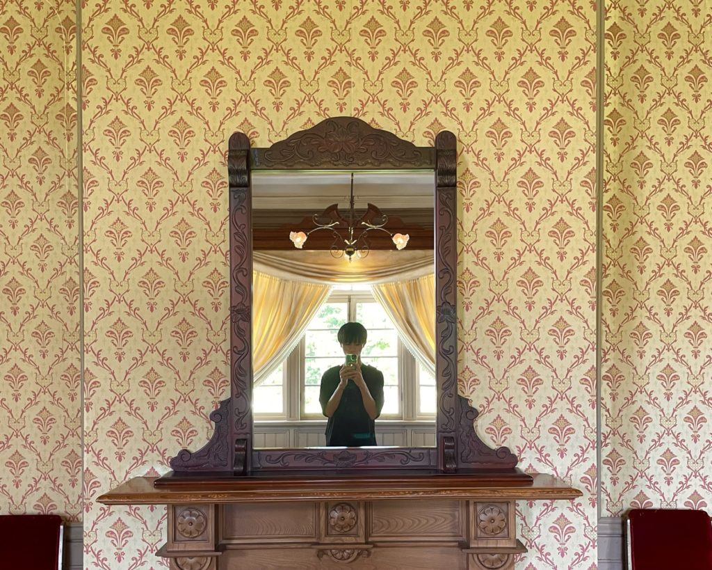 仁風閣内にある鏡で自撮りする人